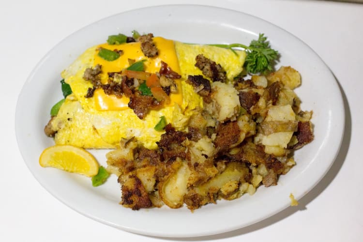 Plain cheese omelete with potatoes on a ceramic plate