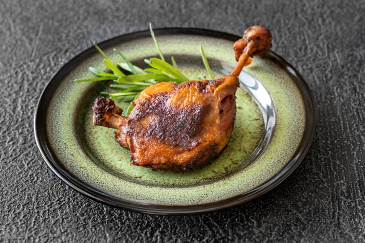 Duck confit served on a green ceramic plate