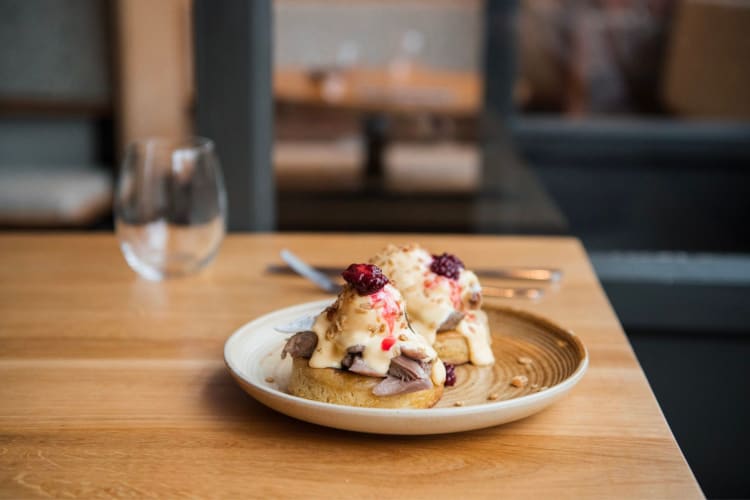 Duck leg served on a warm crumpet with poached eggs and sweet toppings