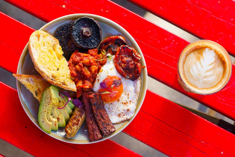 a hearty plate of vegan breakfast foods and a latte 