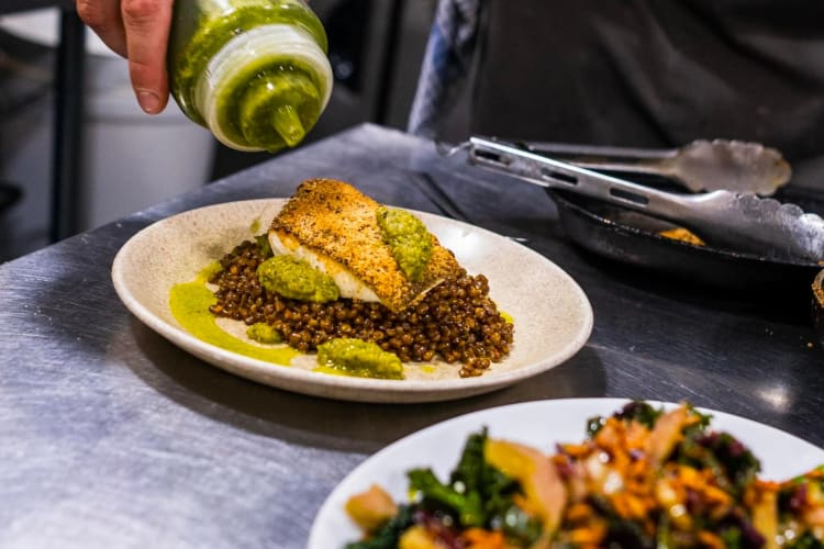 At this renowned Leeds restaurant, a chef adds a flavourful sauce to a beautifully plated fish dish 