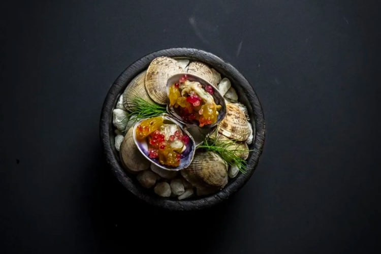 An exquisite tasting menu dish featuring a delicately presented clam