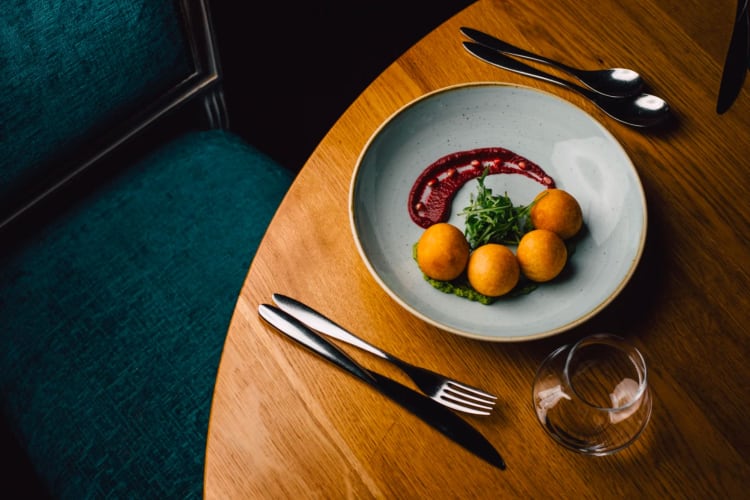 Spiced paneer and spinach dough balls served with a caraway infused tomato raso