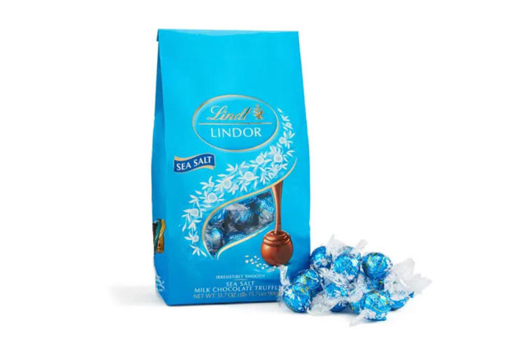 A box of Sea Salt Lindor chocolate flavor truffles next to some loose truffles