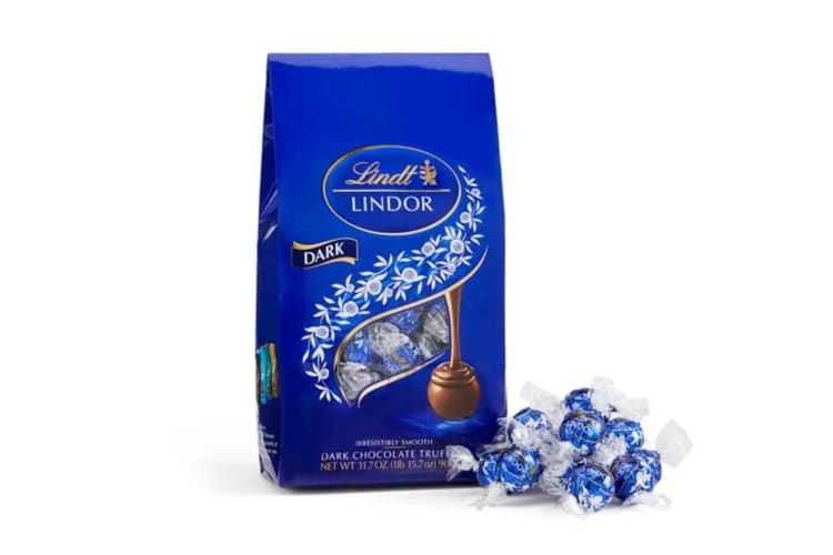 A box of Lindor Dark truffles next to some loose truffles