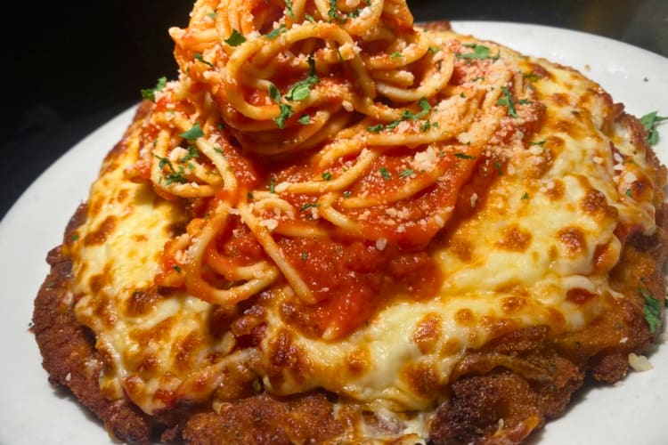 Chicken Parmesan topped with spaghetti