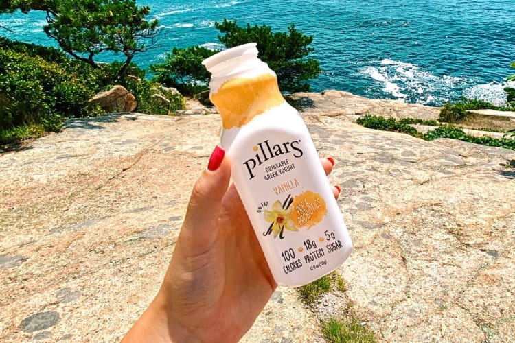 A hand holding a Pillars Drinkable Greek Yogurt