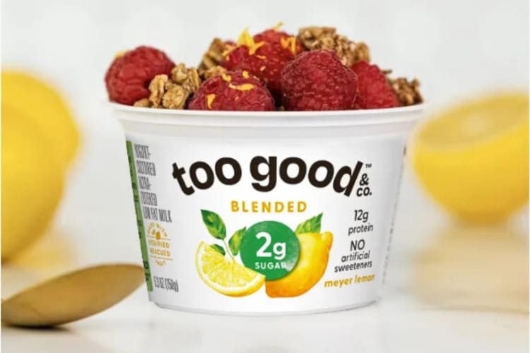 A cup of Too Good & Co. Blended low-calorie yogurt topped with raspberries and granola