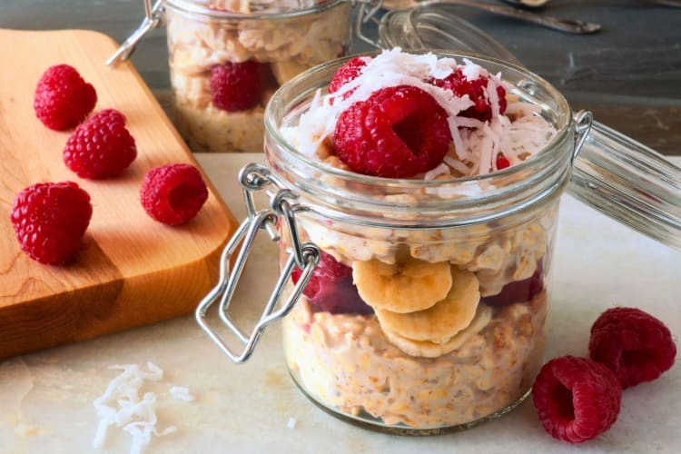 Breakfast overnight oats with fresh raspberries in a jar.