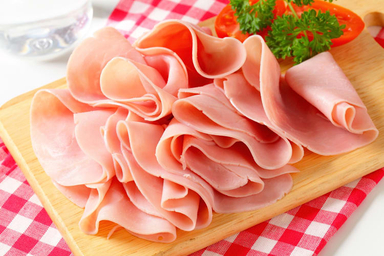 Lunch meat slices on a wooden serving board