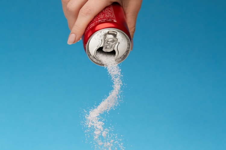 A can pouring out sugar.