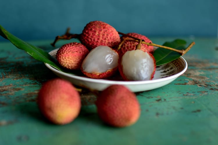 Lychees and leaves on a ceramic plate