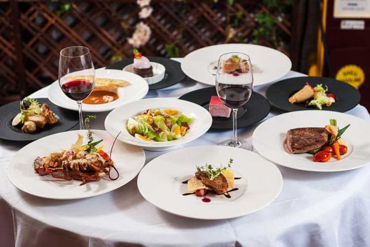 An assortment of French meals and two glasses of red wine on a table