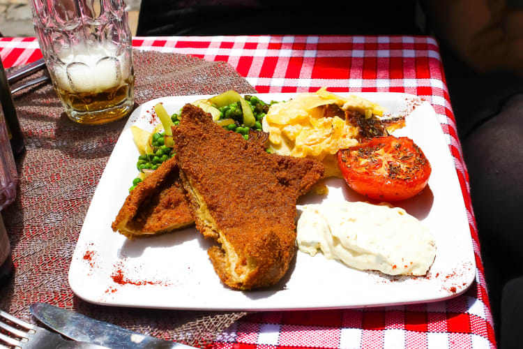 French tripe served with peas, tomato and other foods on a white plate