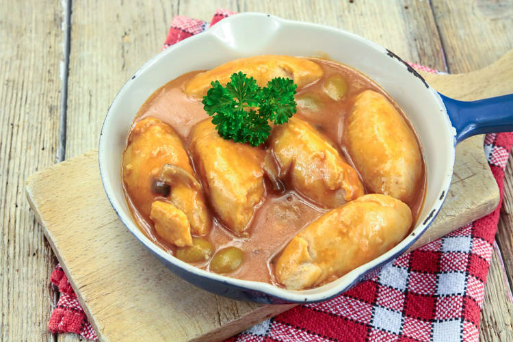 Quenelles de brochet, a delicious Lyon food, in a bowl, served on a wooden board