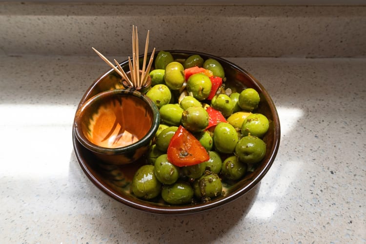 A bowl of Aloreñas olives, a popular Malaga food, with peppers and toothpicks