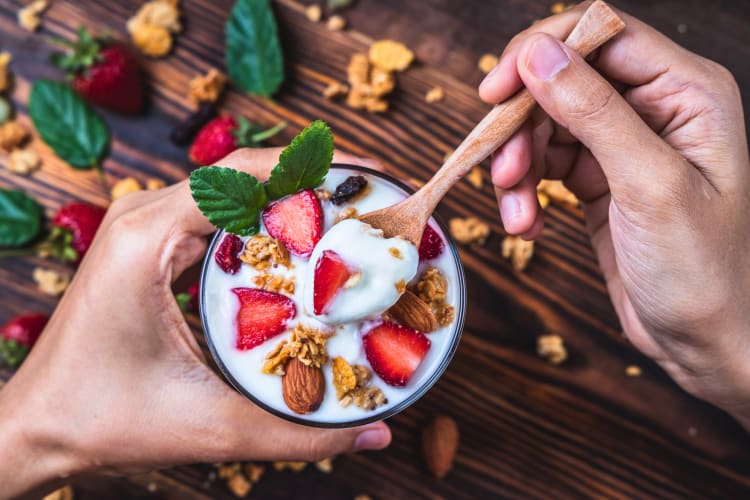 man eating Greek yogurt with fruits