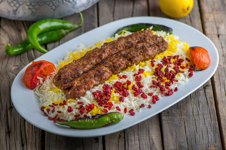 Two chelo kebabs on a bed of rice