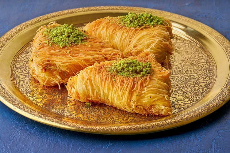 Three portions of baklawa on a gold plate