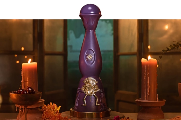 A bottle of Clase Azul tequila in between two burning candles