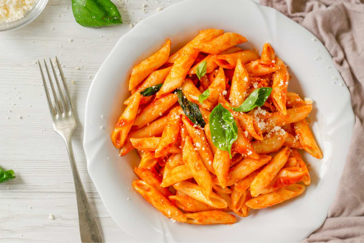 Penne pomodoro served with basil