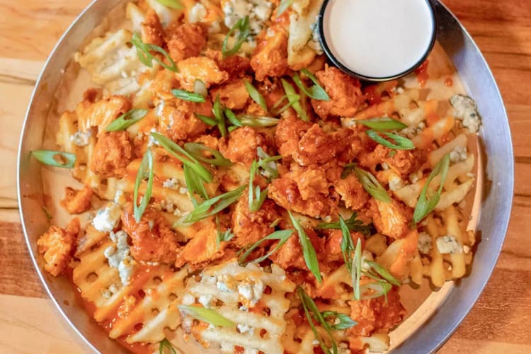 Waffle fries topped with crispy buffalo chicken, bleu cheese, buffalo sauce drizzle and green onions 