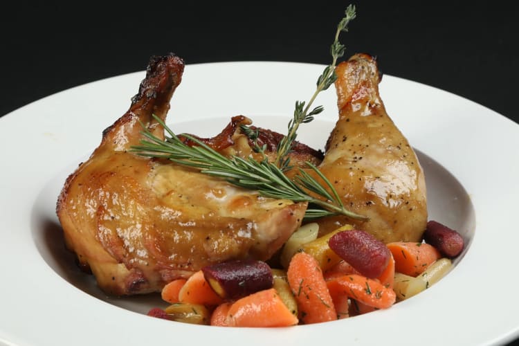 Roasted half chicken served with vegetables and rosemary