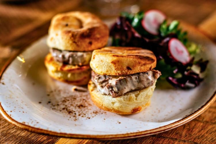 Grilled tenderloin sandwiched between two pieces of biscuit and a side of salad