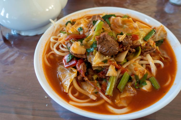 a bowl of lagman noodles with beef