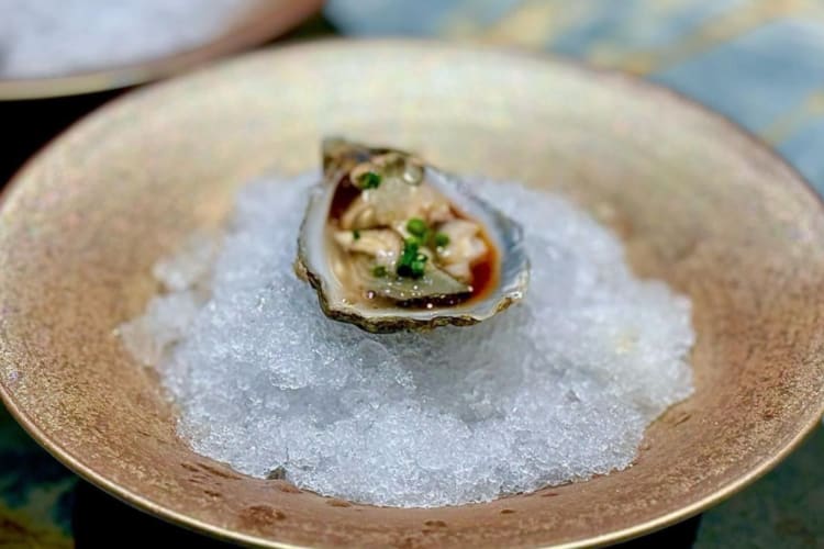 a Kumomoto oyster on ice in a bowl