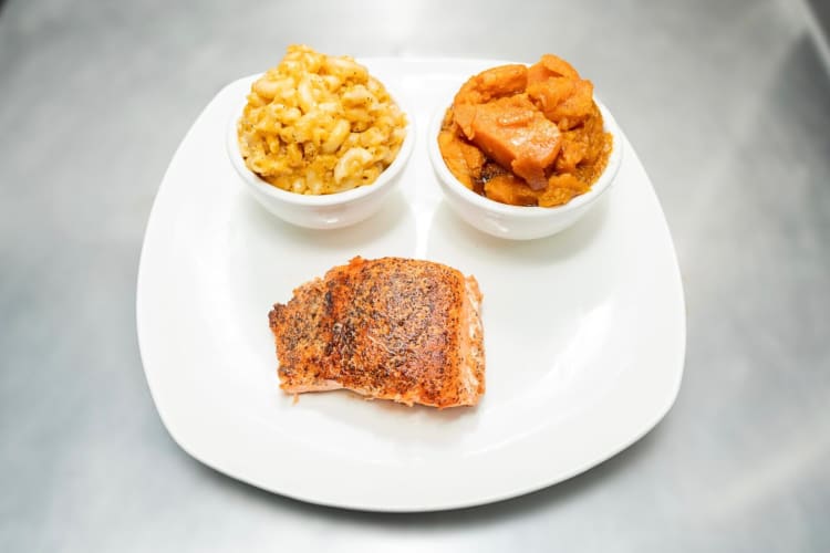 An NYC street food meal of honey-glazed salmon with two sides, from GG’s Fish and Chips 