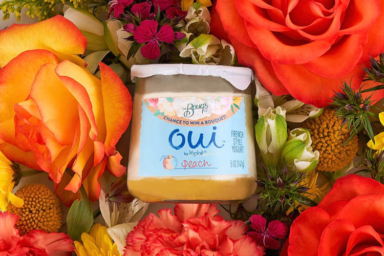 A peach Oui yogurt flavor surrounded by flowers