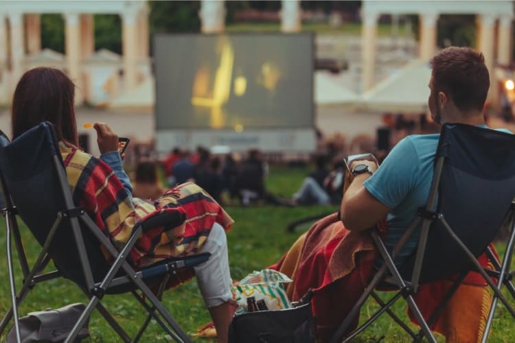 A couple watches a movie outdoors