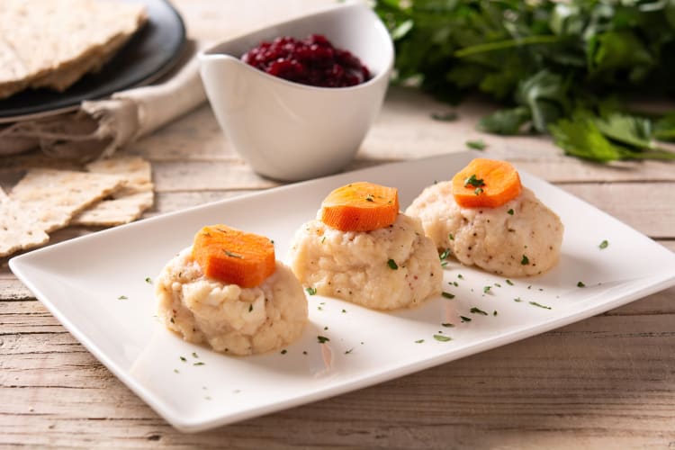 Three portions of gefilte fish, a popular Passover food, on a white plate