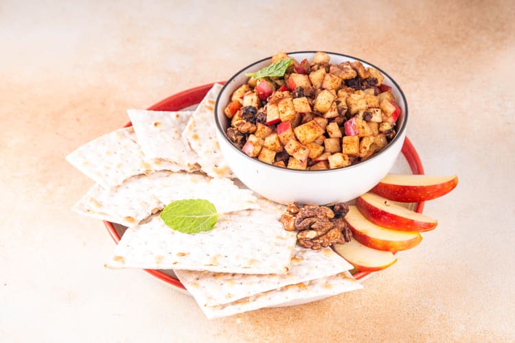 A bowl of charoset with apple slices and matzo — a popular Passover food combination