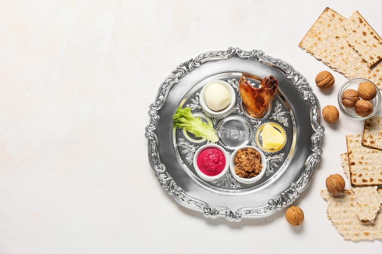 Aerial view of a Seder plate with the six essential foods, next to pieces of matzo