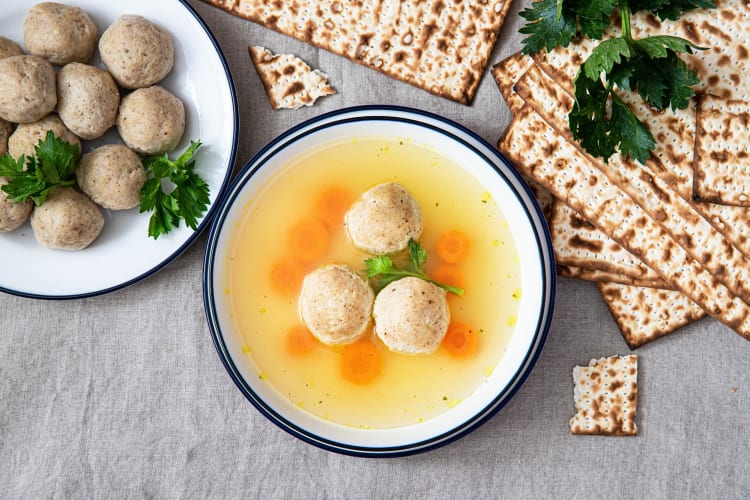 Aerial view of matzo ball soup, matzo balls and matzo bread
