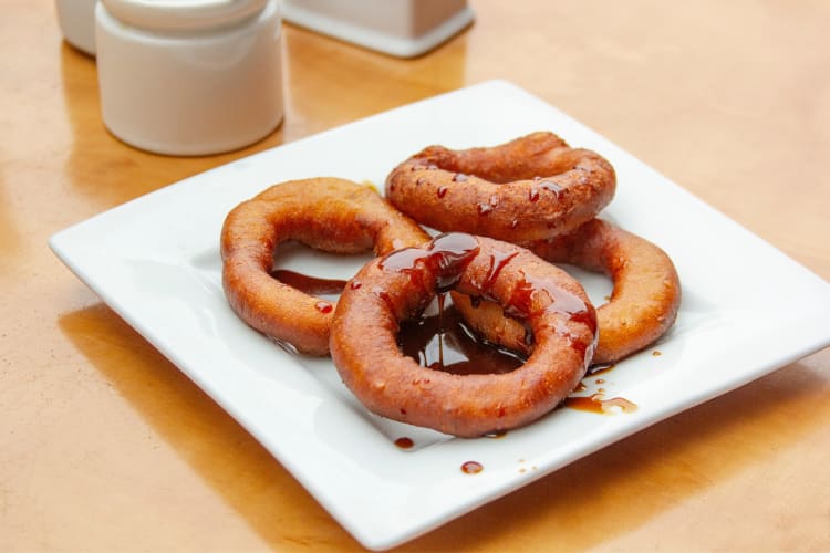 picarones, fried Peruvian doughnuts, drizzled with syrup