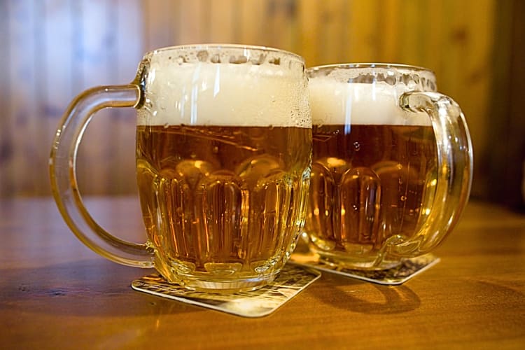 Two mugs of Plzenské Pivo, a popular Czechia beer often ordered with Prague food