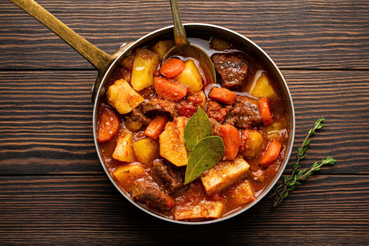 Aerial view of a pot of lamb stew with a spoon inside of it