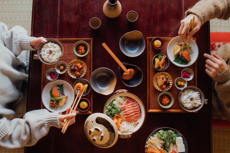 A restaurant table setting with two people eating from various meals 