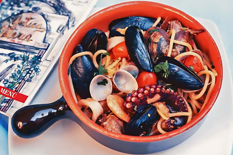 Seafood pignatiello, with mussels, clams, shrimp, squid, octopus, scallops and cannolis, all seasoned with spicy oil
