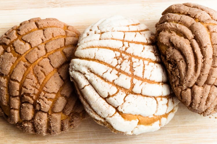 Three mexican conchas on a wooden table