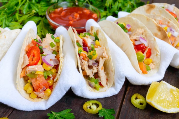 Fish and vegetable tacos served with lemon and salsa