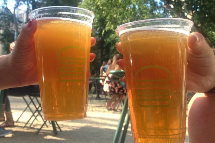 Two hands holding two Shake Shack shandies