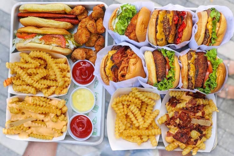 Various Shake Shack burgers, hot dogs, fries and sauce