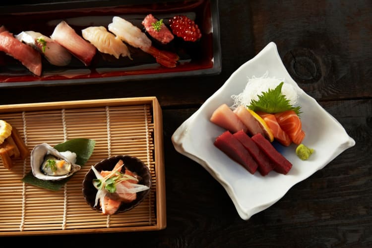 artfully arranged sashimi and nigiri sushi with black background