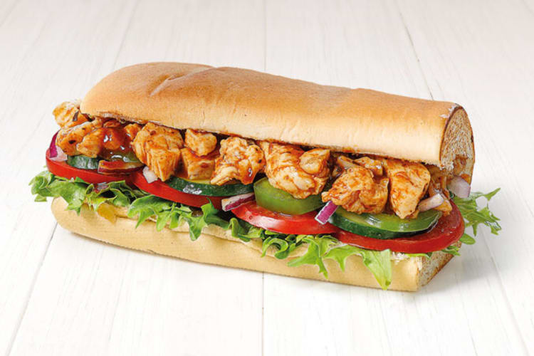 A Subway sub with chicken, vegetables, and sweet and sour sauce