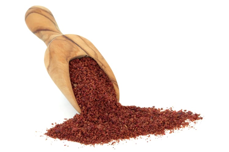 Sumac served from a wooden spoon
