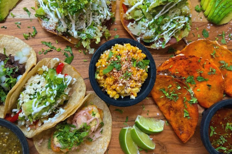 a variety of tacos with sauces and vegetables